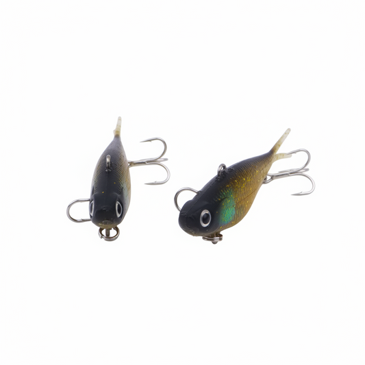 Two gold glitter fishing lures with dark blue bodies, treble hooks, and pointed tails