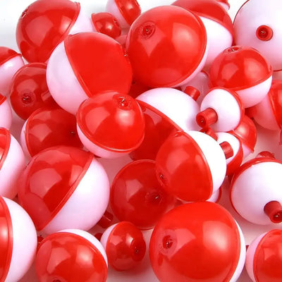 Close-up of red and white round fishing bobbers with push-button caps