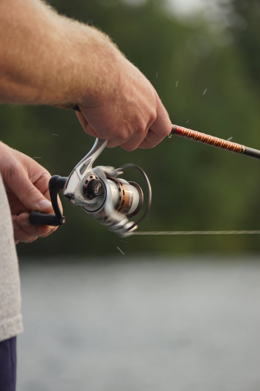 Angler holding a fishing rod and reel — beginner's guide to fishing lures and baits