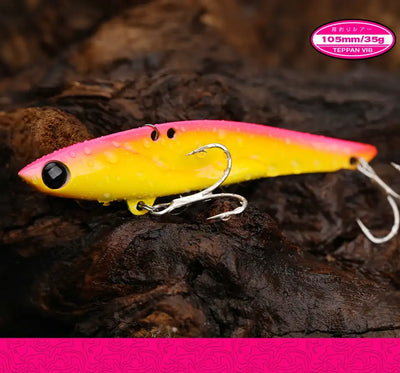 Yellow metal vibration fishing lure with black eye and three treble hooks