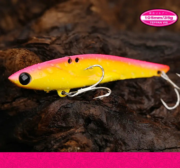 Yellow metal vibration fishing lure with black eye and three treble hooks