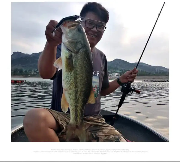 Metallic silver-green swimbait lure with treble hooks held beside a fish catch.