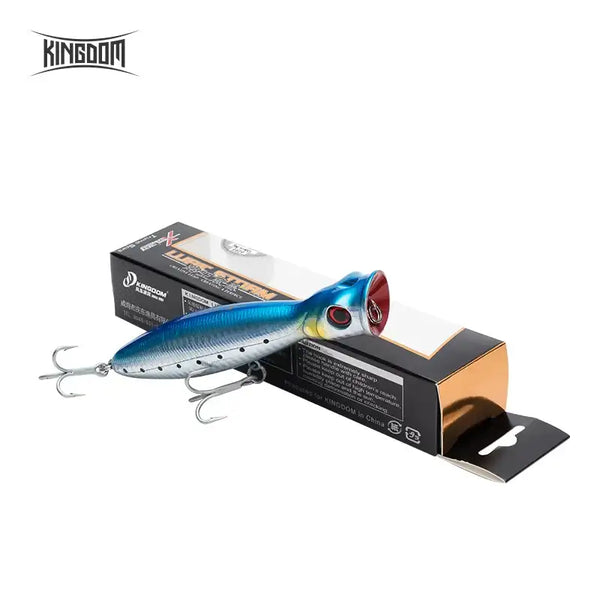 Blue and silver floating popper fishing lure with treble hooks in retail packaging.