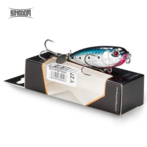 Silver-blue holographic topwater pencil lure with treble hooks, shown in retail box