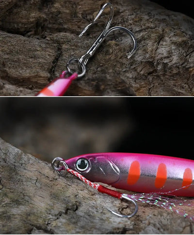 Pink and purple metal fishing jig lure with orange accents and double hook on rock