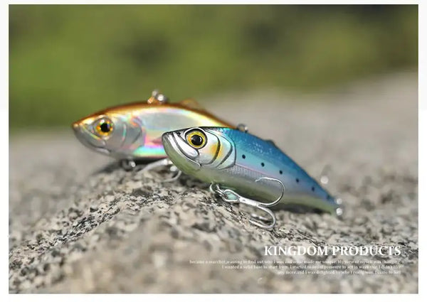Fishing lure close-up, orange and blue silver body with treble hooks on rock