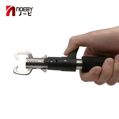 Black hook remover pliers held in hand, silver jaw tool for removing hooks