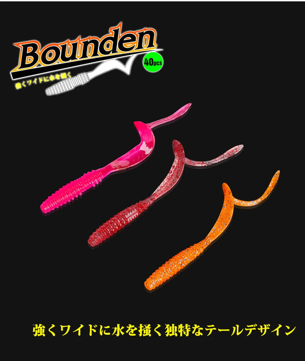 Pink, red, and orange soft plastic worm lures with curved tail shapes.