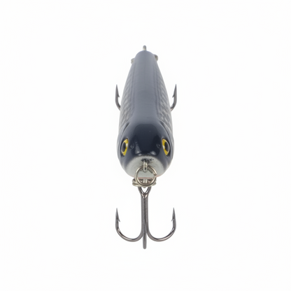 Surface walking-dog fishing lure, front view, dark blue speckled body, yellow eyes, treble hooks