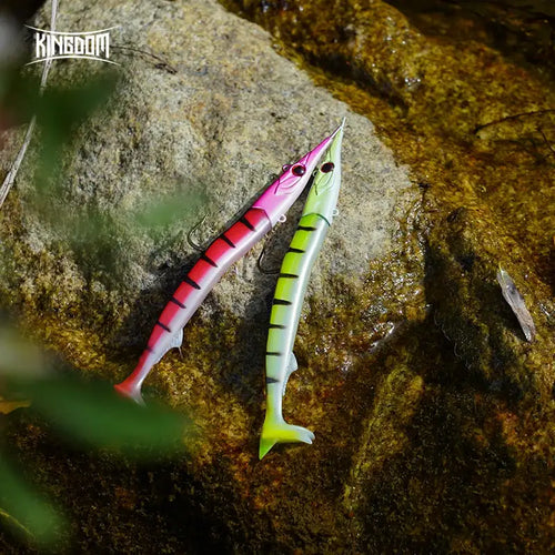 Pink and green paddle-tail soft fishing lures with jig heads on rocky water