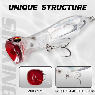 Floating lure close-up with prismatic clear body, red lip, and two treble hooks