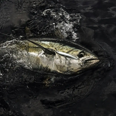 Silver-and-olive lipless minnow sinking lure with large black eye and treble hooks