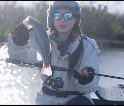 Spinning reel on fishing rod, red spool and black reel body in outdoor scene