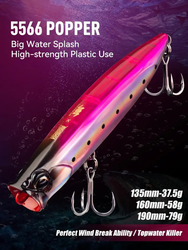 Floating popper fishing lure, magenta-pink and silver gradient, red mouth, black dots, treble hooks