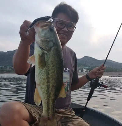 Angler holding a large fish with a striped jointed minnow lure