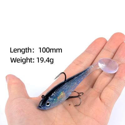 Blue iridescent soft lure held in hand with treble hooks, 19.4g