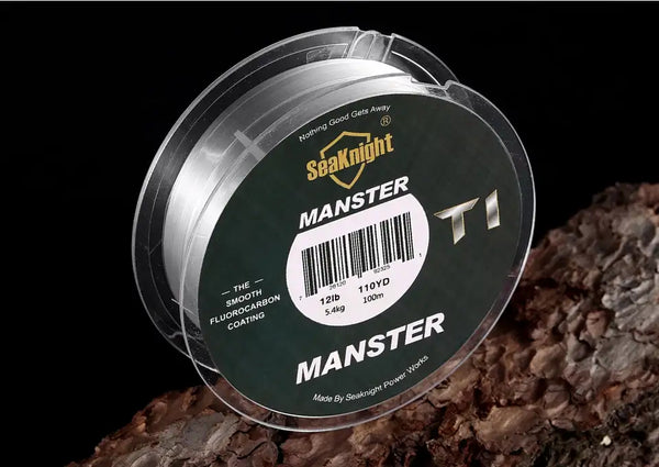 Fishing line spool with MANSTER T1 label and transparent monofilament line near rocks