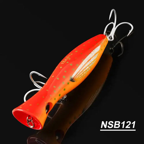Orange topwater popper hard bait with speckled pattern and treble hooks