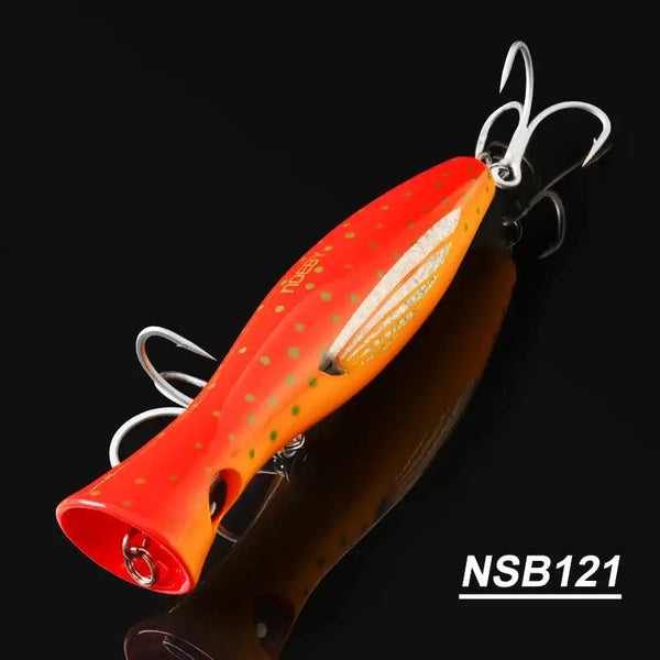 Orange topwater popper hard bait with speckled pattern and treble hooks