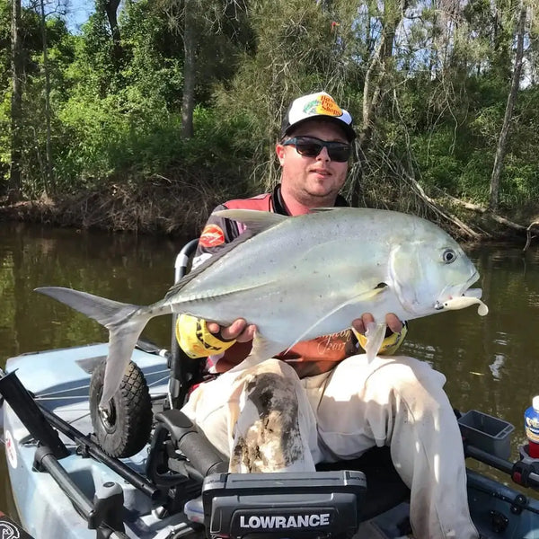 Bass caught with lure: Noeby paddle tail shad swimbait in person’s hand by boat