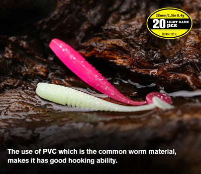 Soft plastic worm lures: pink, white, and pale green on a wet dark surface