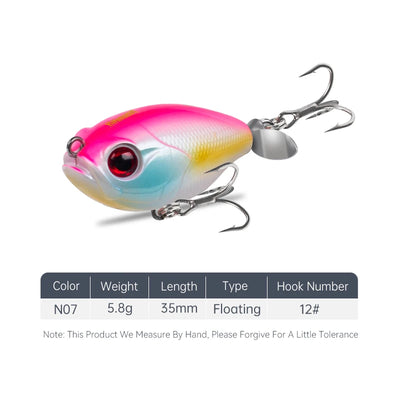 Floating topwater lure, pink-blue-yellow body with red eye and silver treble hooks