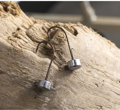 Ned jig lead head fishing hooks with barbed tips on weathered wood
