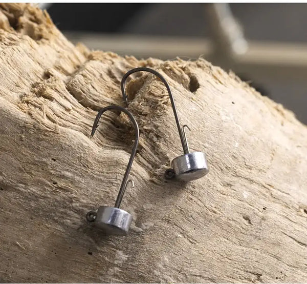 Ned jig lead head fishing hooks with barbed tips on weathered wood