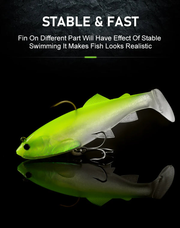 Paddle-tail soft swimbait in green and silver with treble hooks, side profile