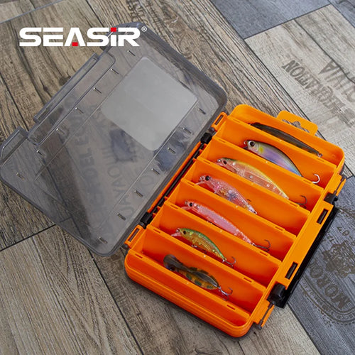 Orange double-sided tackle box with clear lid open, showing molded lure compartments