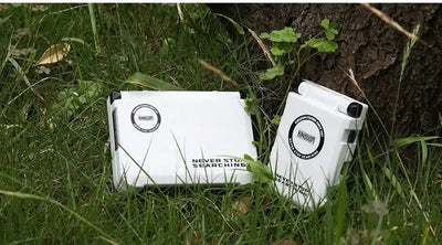 Mini fishing tackle box storage case, white, closed with side clasp on grass