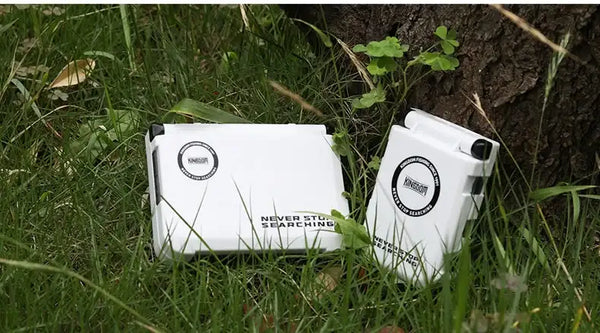 Mini fishing tackle box storage case, white, closed with side clasp on grass