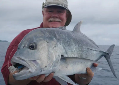 Large saltwater game fish held beside Noeby lure-style topwater fishing