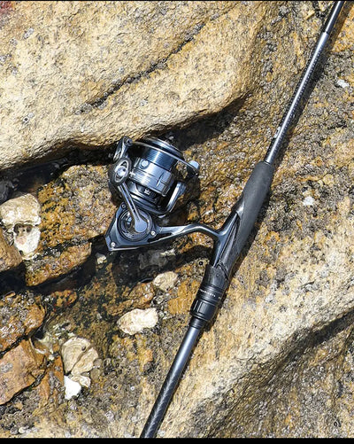 Tsurinoya long-cast spinning reel with silver spool and curved handle on black rod