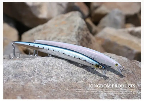 Kingdom Isca artificial fishing lure on rocks, silver-blue body with treble hooks