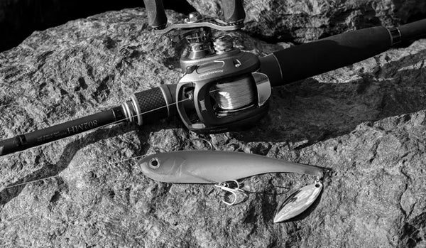 Gray-toned fishing lure with spinner blade and treble hook