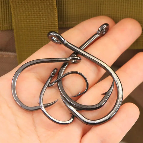 Set of curved black live bait hooks resting in a hand