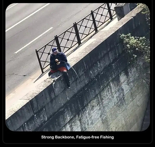 Angler holding a spinning fishing rod outdoors near a concrete ledge