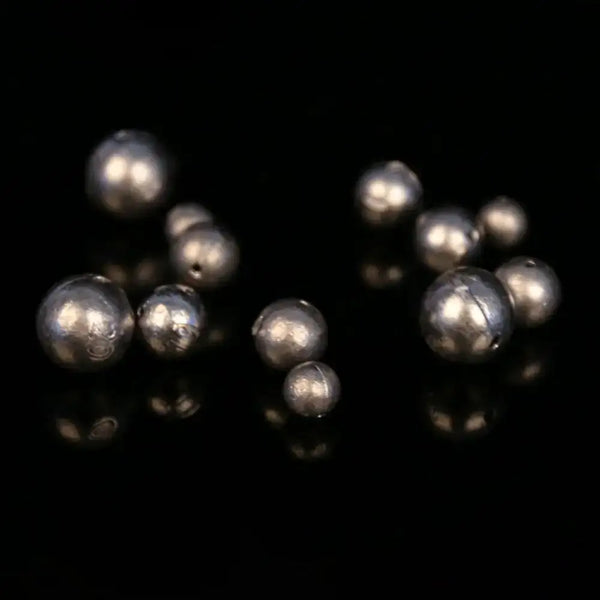 Cluster of dark gray round hollow lead ball sinkers, pendant style with holes