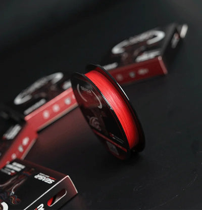 Red PE braided fishing line spool with SEASIR reel and nearby SEASIR boxes