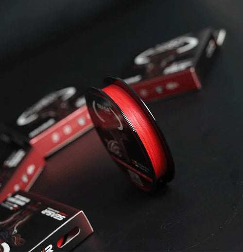 Red PE braided fishing line spool with SEASIR reel and nearby SEASIR boxes