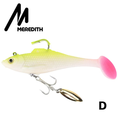 Green-and-white soft plastic swimbait lure with pink tail and gold spinner blade