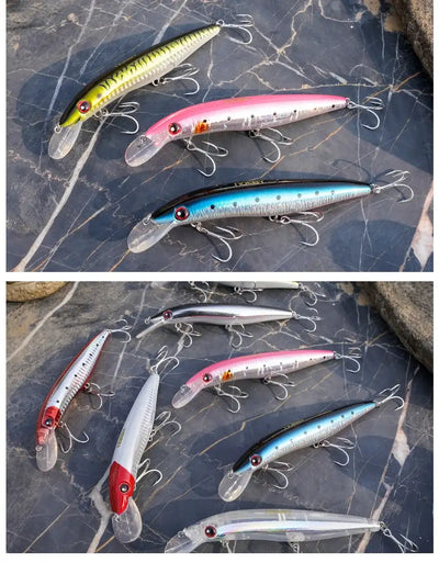 Three shallow trolling minnow lures on blue stone, yellow, pink, and blue chrome bodies