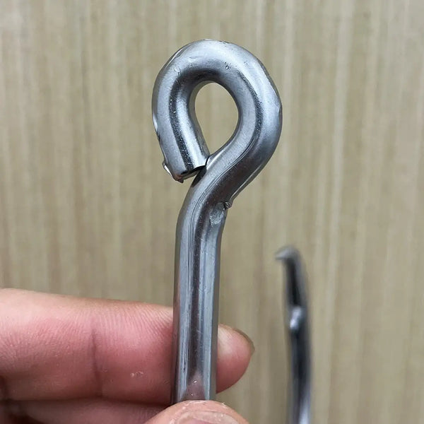 Stainless steel circle hook with ring eye, held for close-up inspection