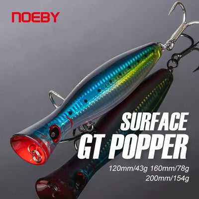 Topwater GT popper fishing lure, blue-green body with red face and treble hook