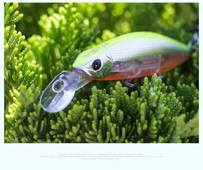 Blue and orange slow-sinking minnow lure with clear lip and treble hooks on green plants