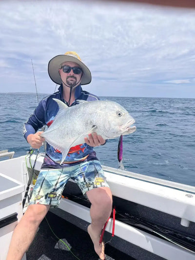 Angler holding a large fish caught while trolling with a minnow-style lure