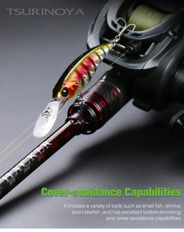 Suspending minnow lure near baitcasting reel, yellow-green body with red stripe, treble hooks