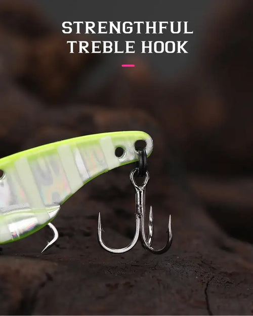 A bright lime-green and silver metallic tsurinoya ares-a metal vib lure with treble hook and low centre of gravity