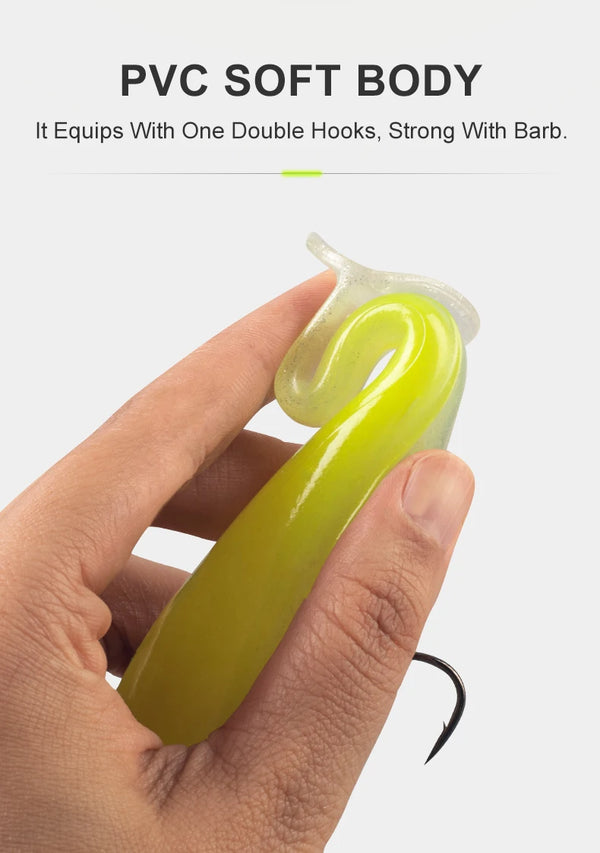 Soft T-tail lure, yellow-green PVC soft body with clear tail fin (held in hand)
